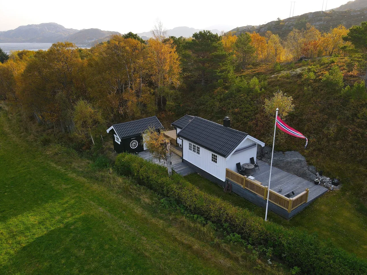 Beige upholstered bed with patterned pillows and ottomans